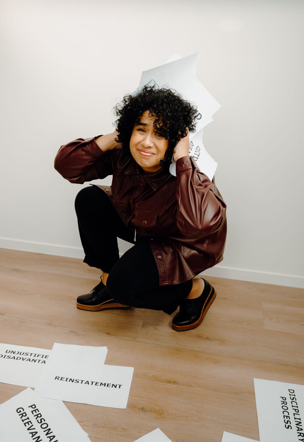 Sanam Permal crouching with employment law documents scattered around her