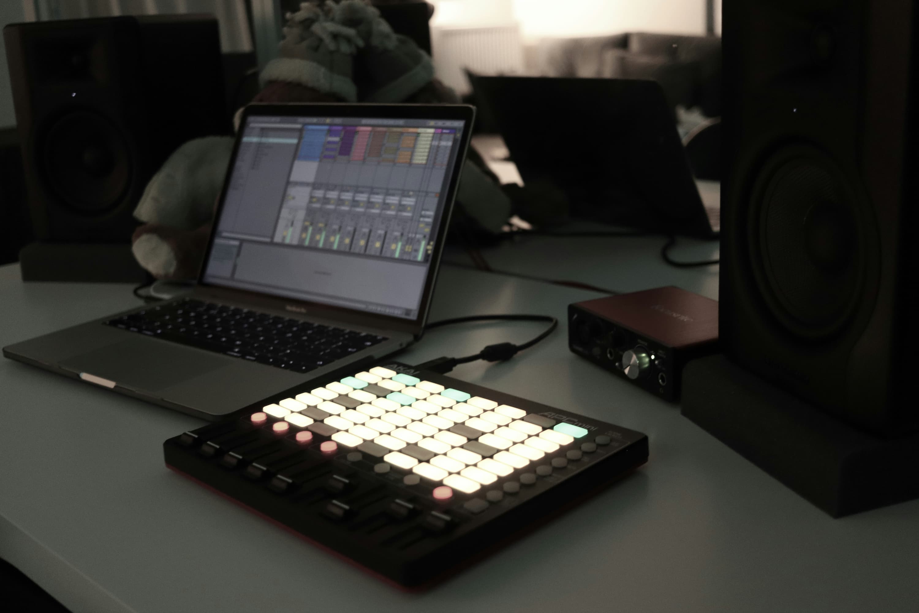 nowoczesne studio muzyczne z różnymi urządzeniami, na laptopie wyświetlany jest program DAW Ableton Live