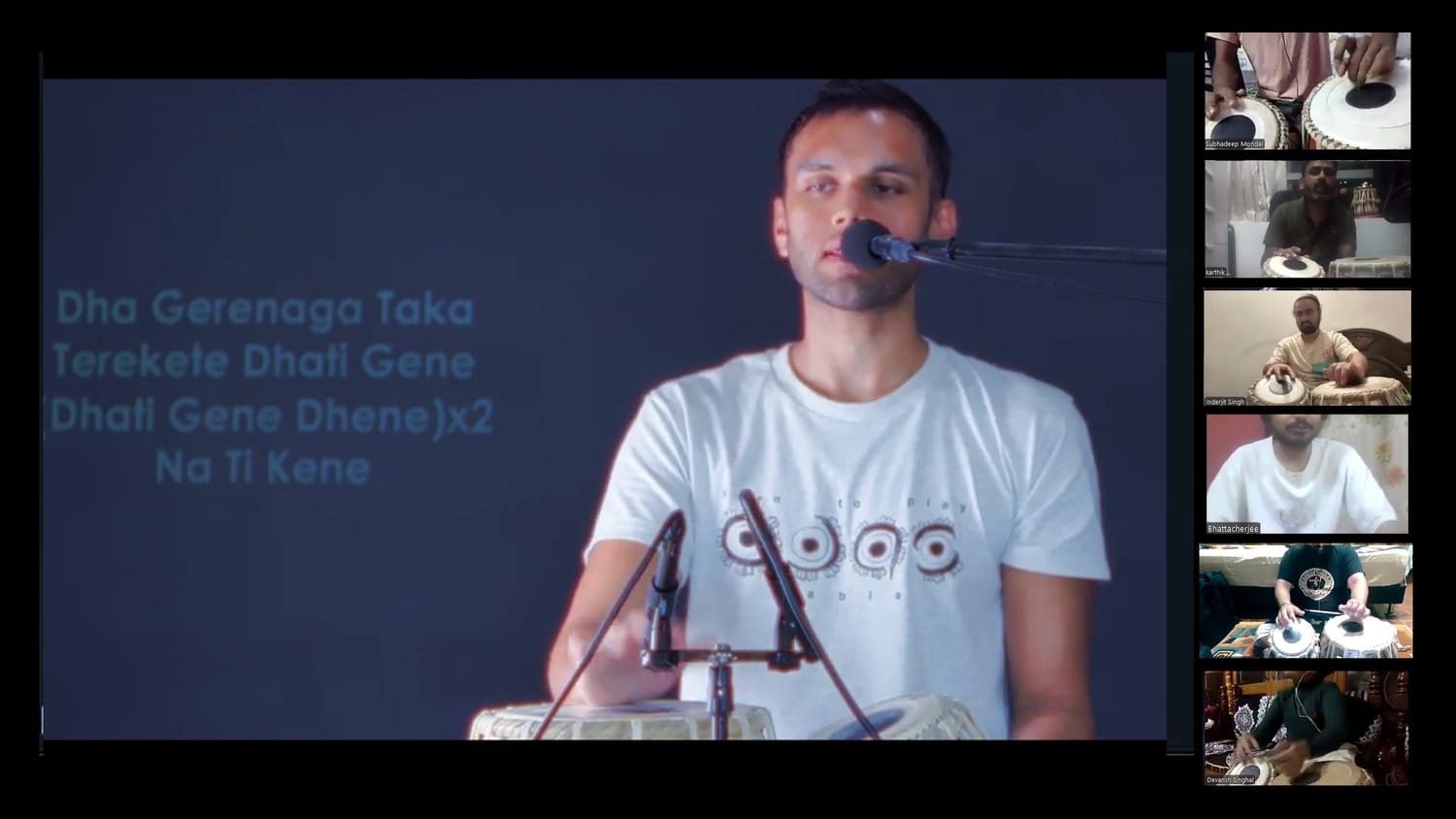 Hands playing dholak in a kirtan setting