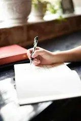 Mano escribiendo en un cuaderno