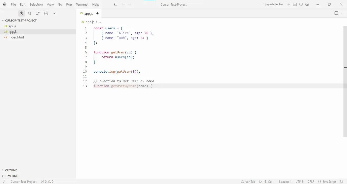 Screenshot of the Cursor code editor on Windows showing a project named “CURSOR-TEST-PROJECT” with three files in the sidebar: api.js, app.js, and index.html. The app.js file is open and contains a JavaScript array named users with two objects: Alice (age 28) and Bob (age 34). Below it is a getUser(id) function that returns a user from the array, followed by console.log(getUser(0));. A comment reading “function to get user by name” appears above the start of a new function declaration, getUserByName(name), with the cursor positioned inside the function body on line 13. The editor interface includes standard menus and a project explorer on the left.