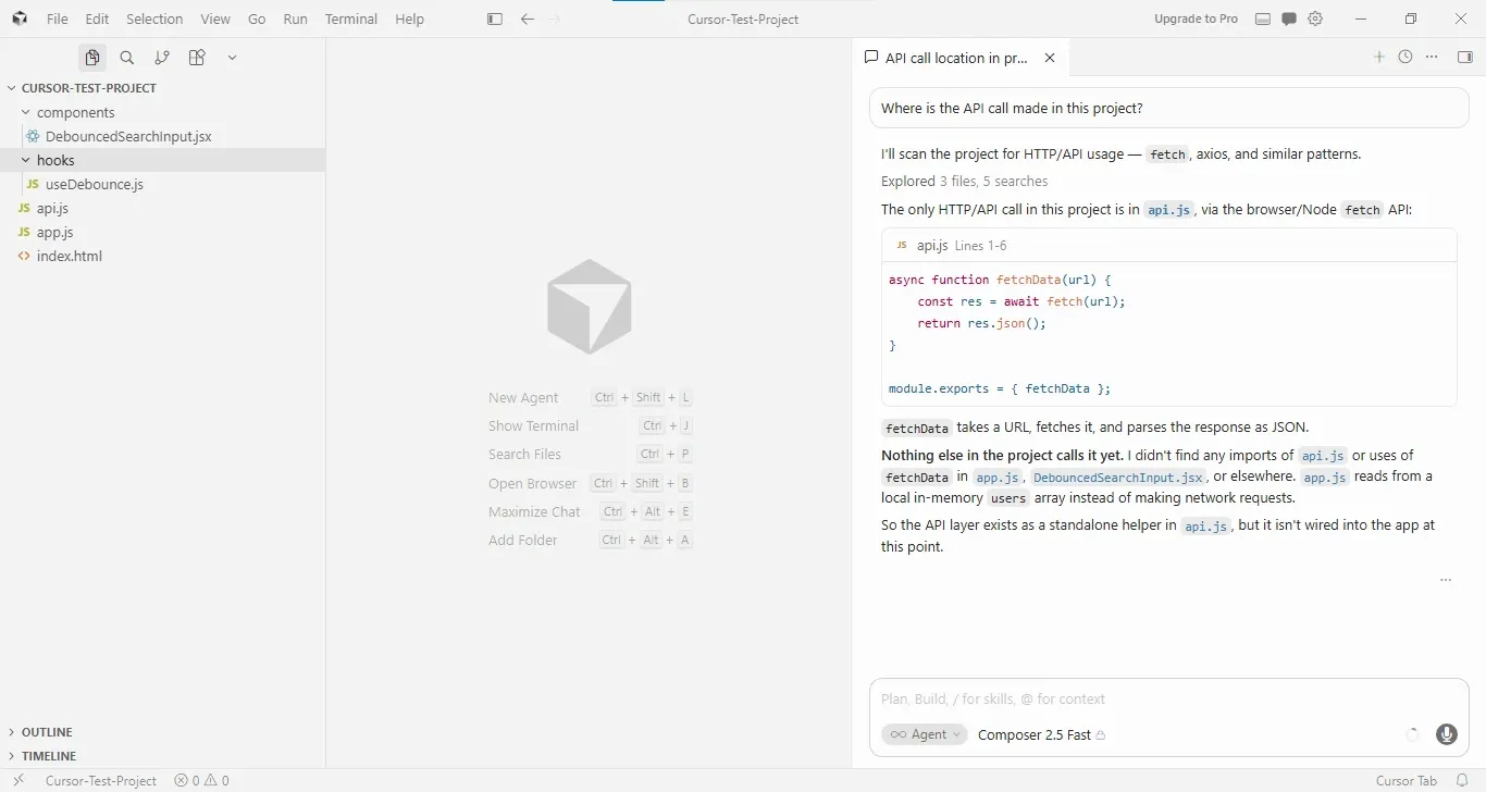 Screenshot of the Cursor editor in a light theme with a project named “CURSOR-TEST-PROJECT” open. The project explorer on the left shows folders named components and hooks, containing files such as DebouncedSearchInput.jsx and useDebounce.js, along with api.js, app.js, and index.html. The central workspace displays Cursor’s start screen with shortcuts for creating a new agent, showing the terminal, searching files, opening a browser, maximizing chat, and adding a folder. On the right, a chat panel titled “API call location in project” shows the user’s question: “Where is the API call made in this project?” The AI assistant explains that it scanned the codebase and explored multiple files to locate HTTP/API usage. The response identifies a single API call in api.js, showing a code snippet for an asynchronous fetchData(url) function that uses the browser’s fetch() API and returns JSON data. The assistant further notes that the function is not currently imported or used elsewhere in the project, including app.js and DebouncedSearchInput.jsx, and concludes that the API layer exists as a standalone helper but is not yet connected to the application. A composer input field and agent controls are visible at the bottom of the chat panel.