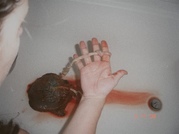Danalise holding the knotted section of her son's umbilical cord after his homebirth
