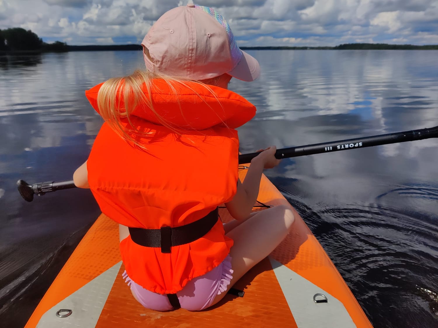 Lapsi suppailemassa järvellä
