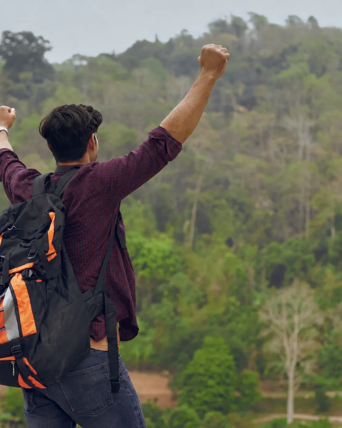 Viajero celebrando una aventura en plena naturaleza
