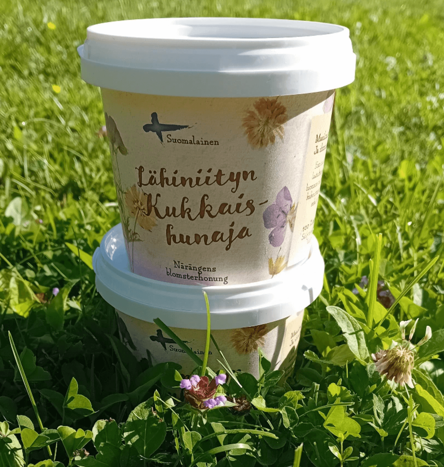 Tuulan mehiläispesän tuottamaa lähiniityn kukkaishunajaa nurmella.