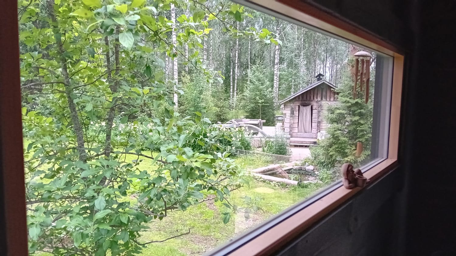 Näkymä pikkusaunan ikkunasta kohti Louhin Turvetuvan savusaunaa.