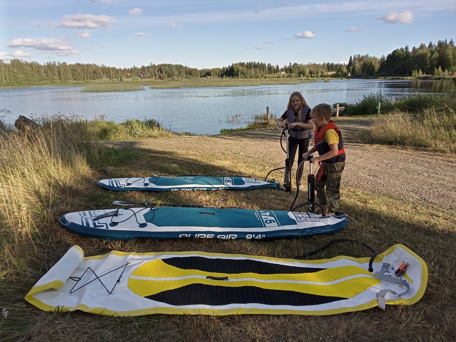 Lapset täyttävät SUP-lautoja rannalla