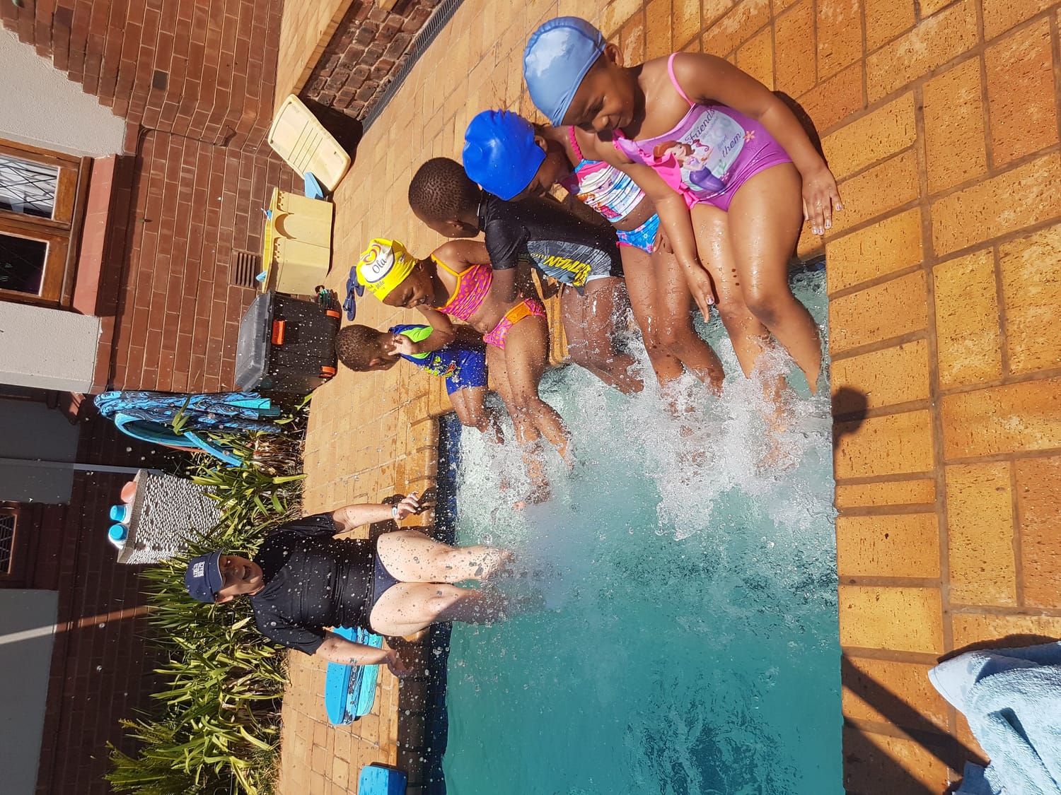 Gail with a row of little swimmers kicking up a splash