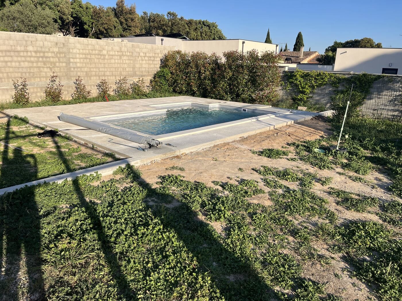 Piscine en fin de chantier, plages posées, jardin encore en terre