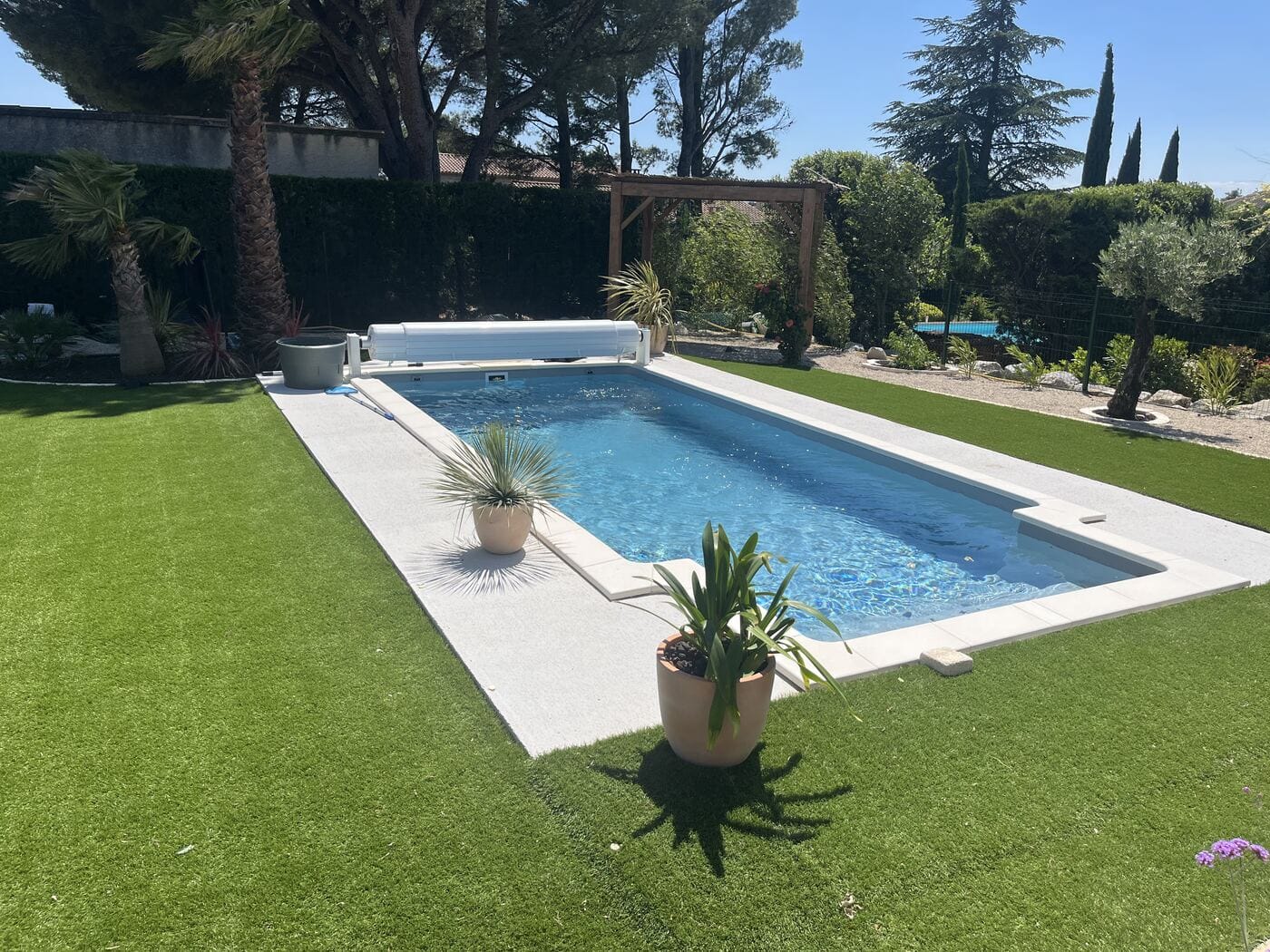 Piscine terminée dans un jardin, plages claires et gazon