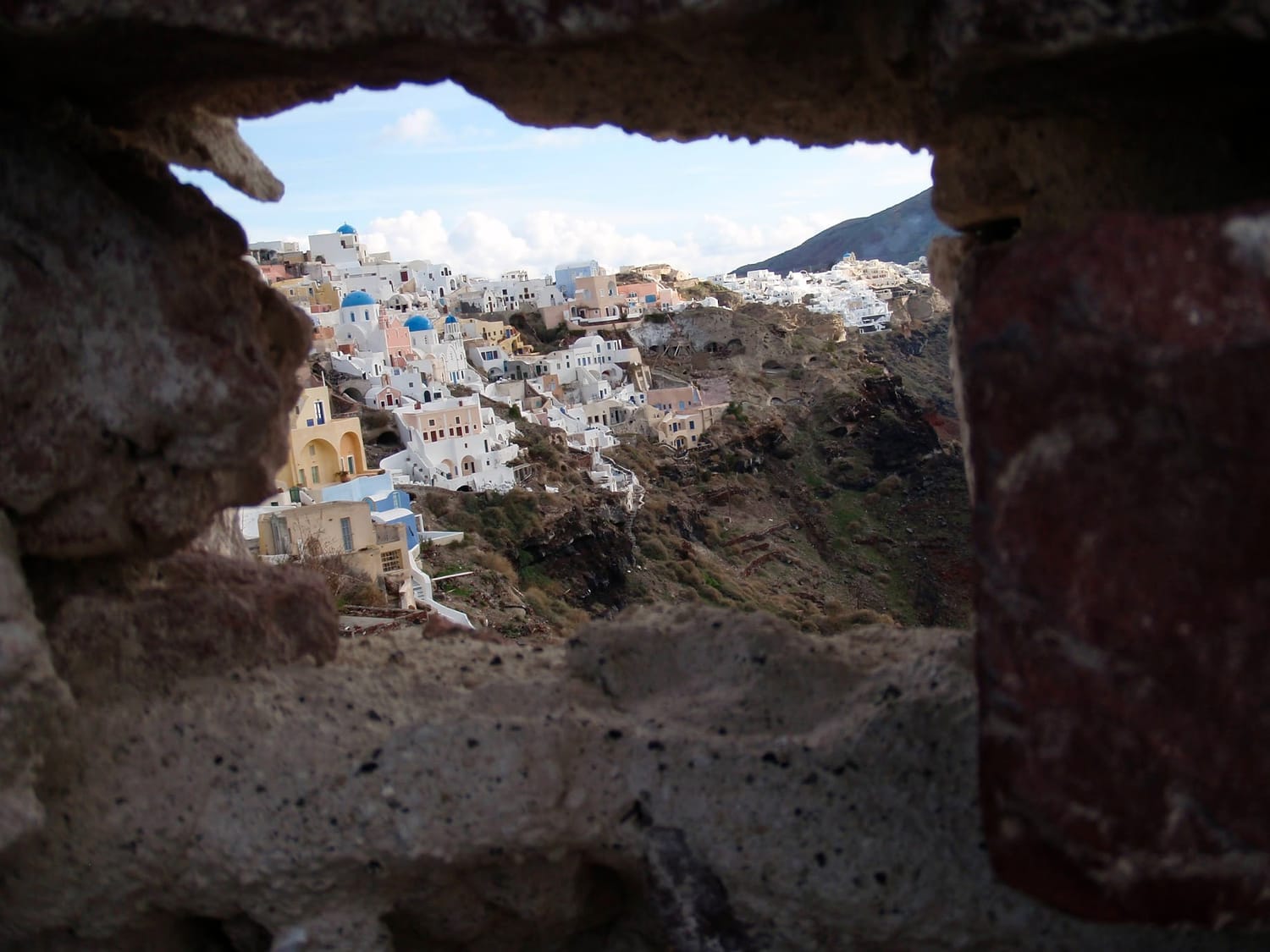 Picture of a coastal town through a rock crevice