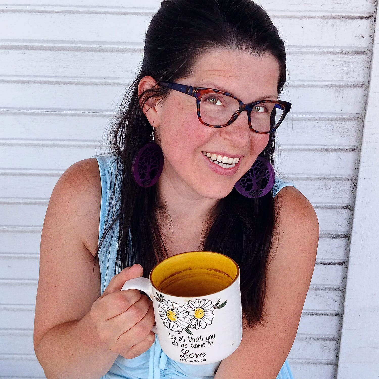 Elissa smiling in warm natural light, holding a daisy mug