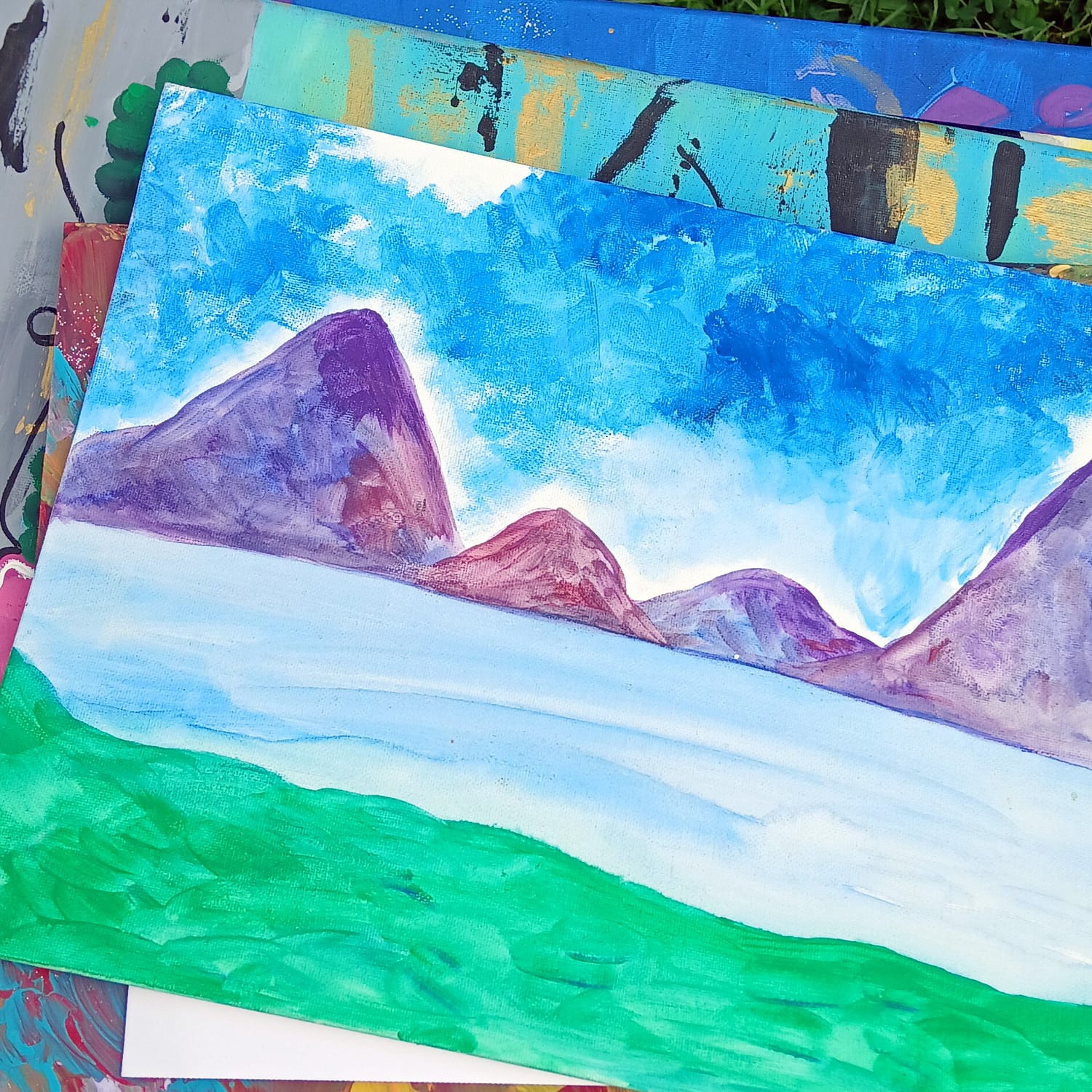 Painting by Elissa: purple mountains over a pale lake under a blue sky