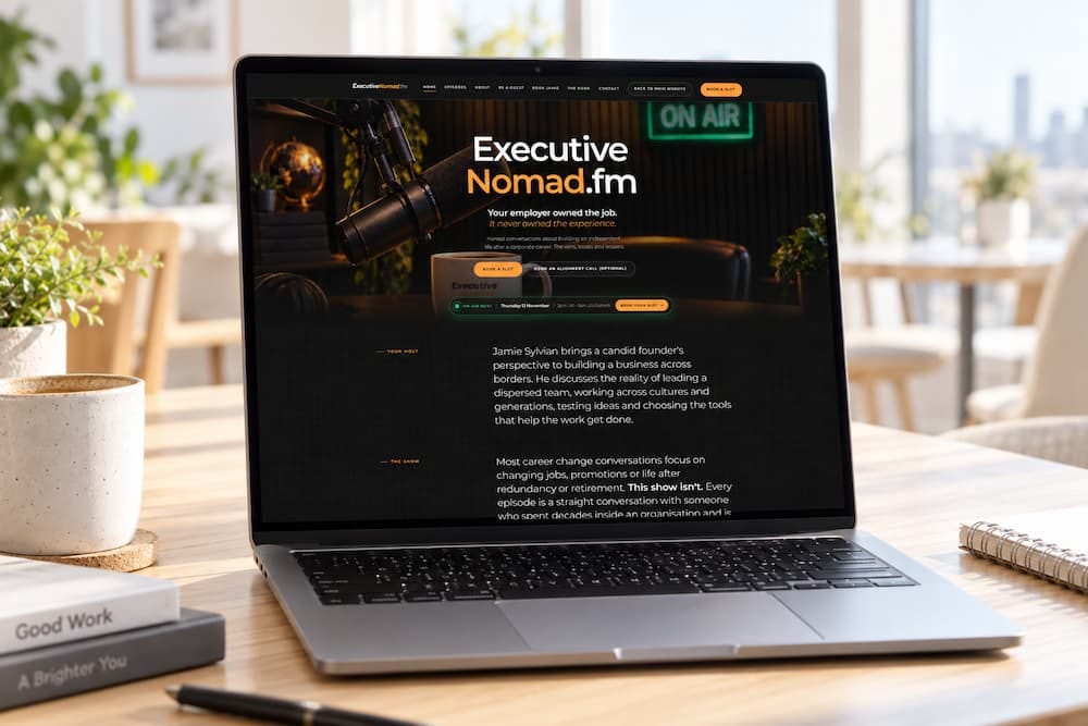 The executivenomad.fm homepage on a laptop