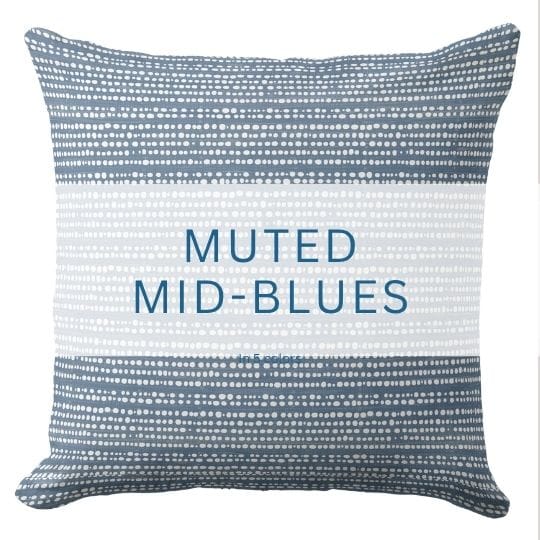 A blue throw pillow in a muted blue hue in a coastal style.
