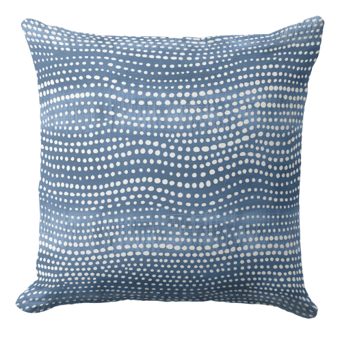 A coral coastal throw pillow featuring a hand block organic waves pattern in white ink on a muted ocean blue background.