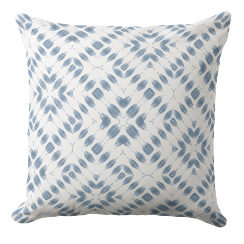 A coral coastal throw pillow featuring a hand block organic waves pattern in white ink on a muted ocean blue background.