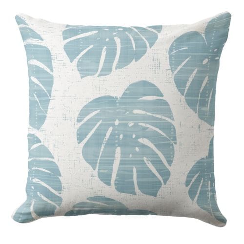 A palm leaf throw pillow in light blue and white in coastal style