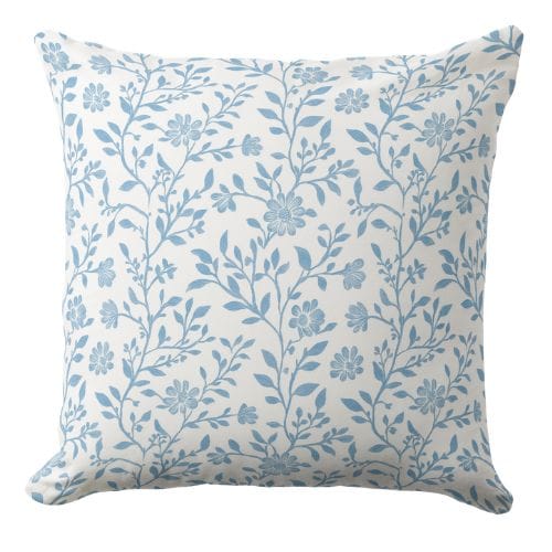 A blue throw pillow in a muted blue hue in a coastal style.