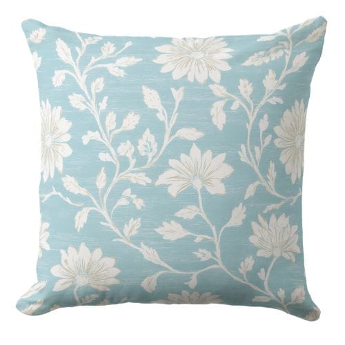 A coastal decorative pillow features a soft decorative cottage style floral print in muted blue and white.