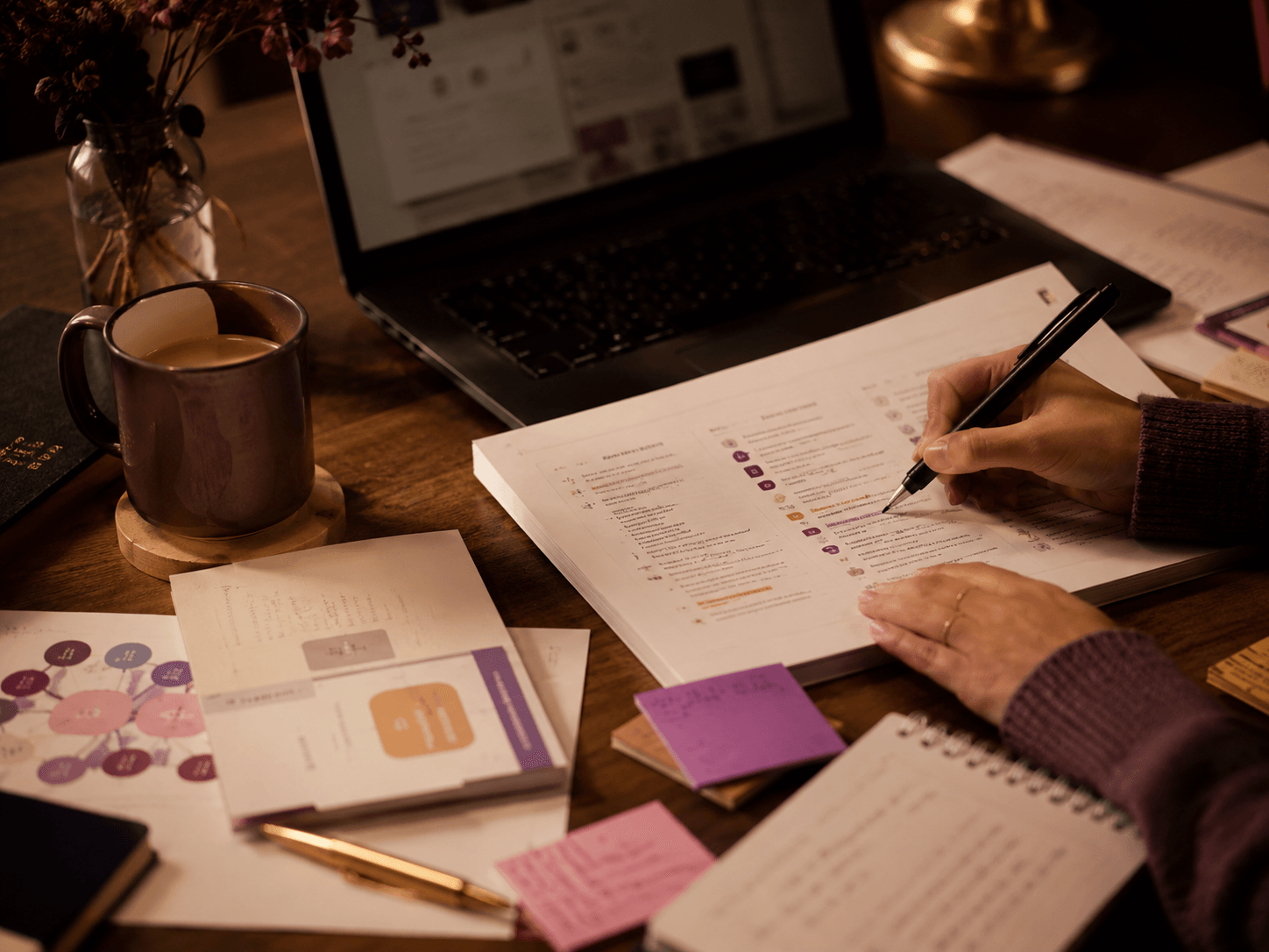 Behind-the-scenes workspace for creating teachings with laptop, notes, tea, and workshop materials
