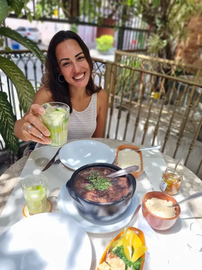 Michele, native Carioca and Rio de Janeiro local travel consultant, enjoying a traditional feijoada and caipirinha at a classic Rio boteco