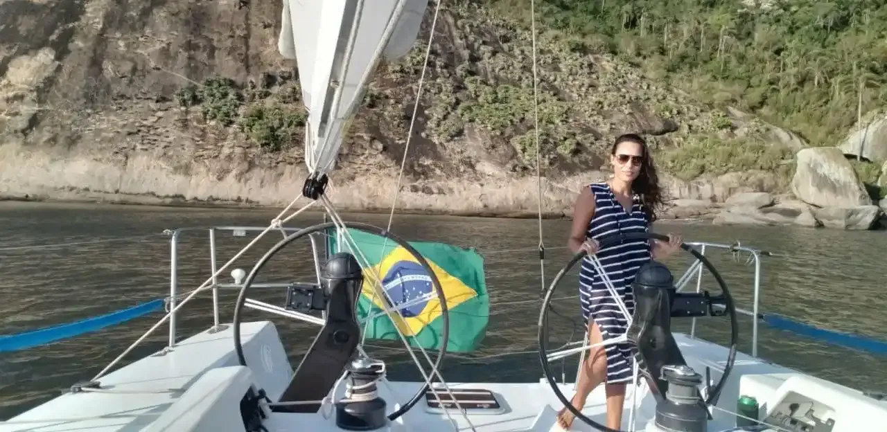 michele on a sailboat with a Brazilian flag