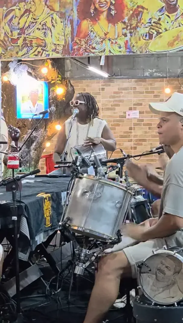 two black man playing drums around a table