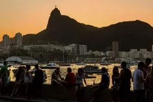 people seated on the seawall watching the sunset in rio