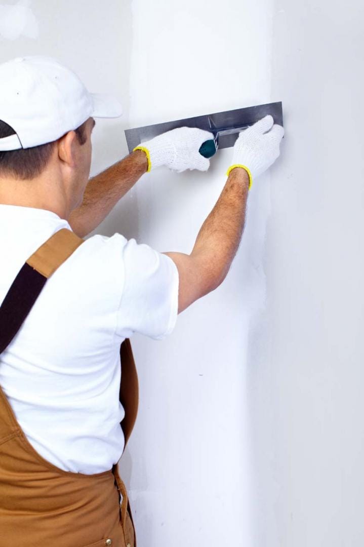 Préparation des murs et application d'enduit de lissage par un artisan