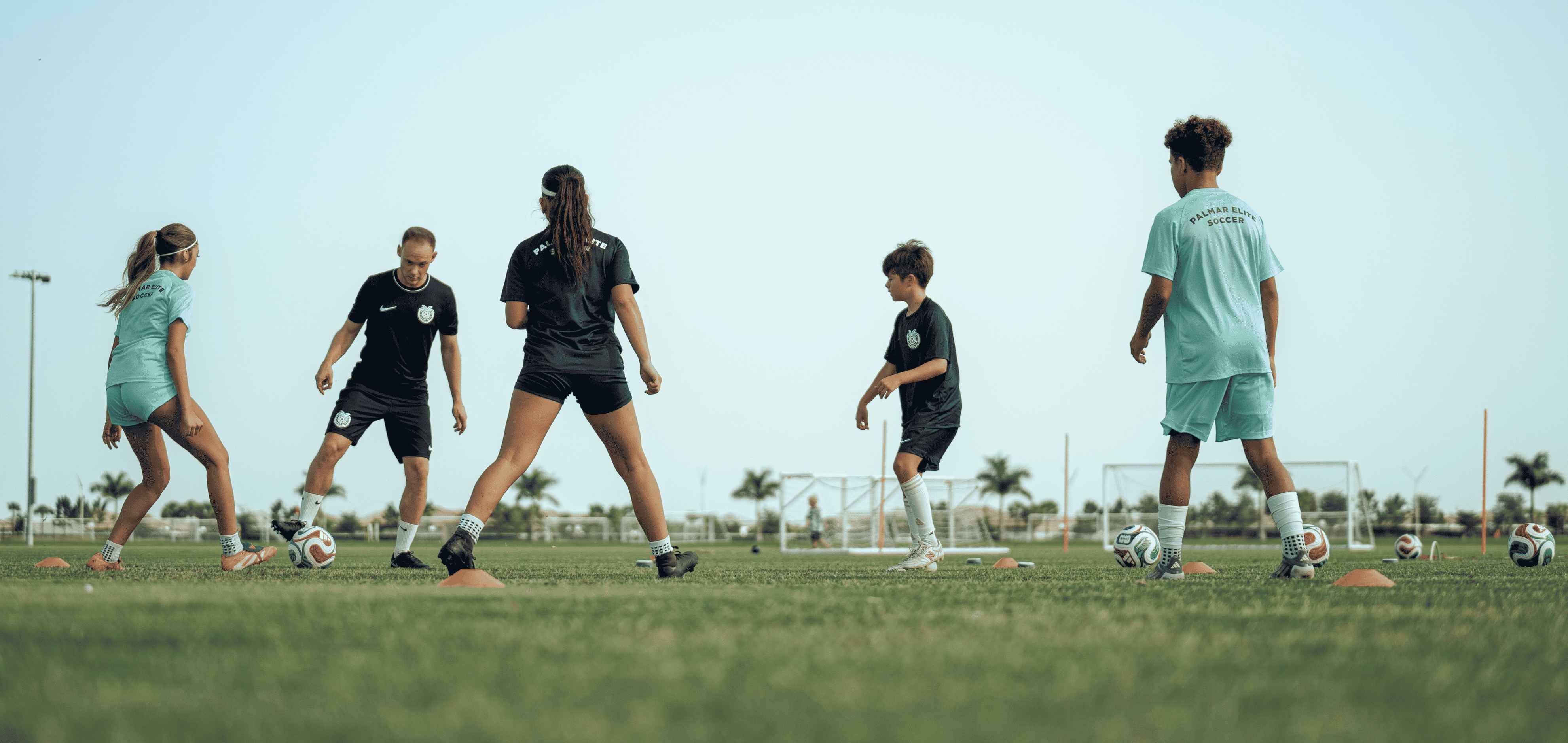 Federico playing soccer with two boys and two girls on the field