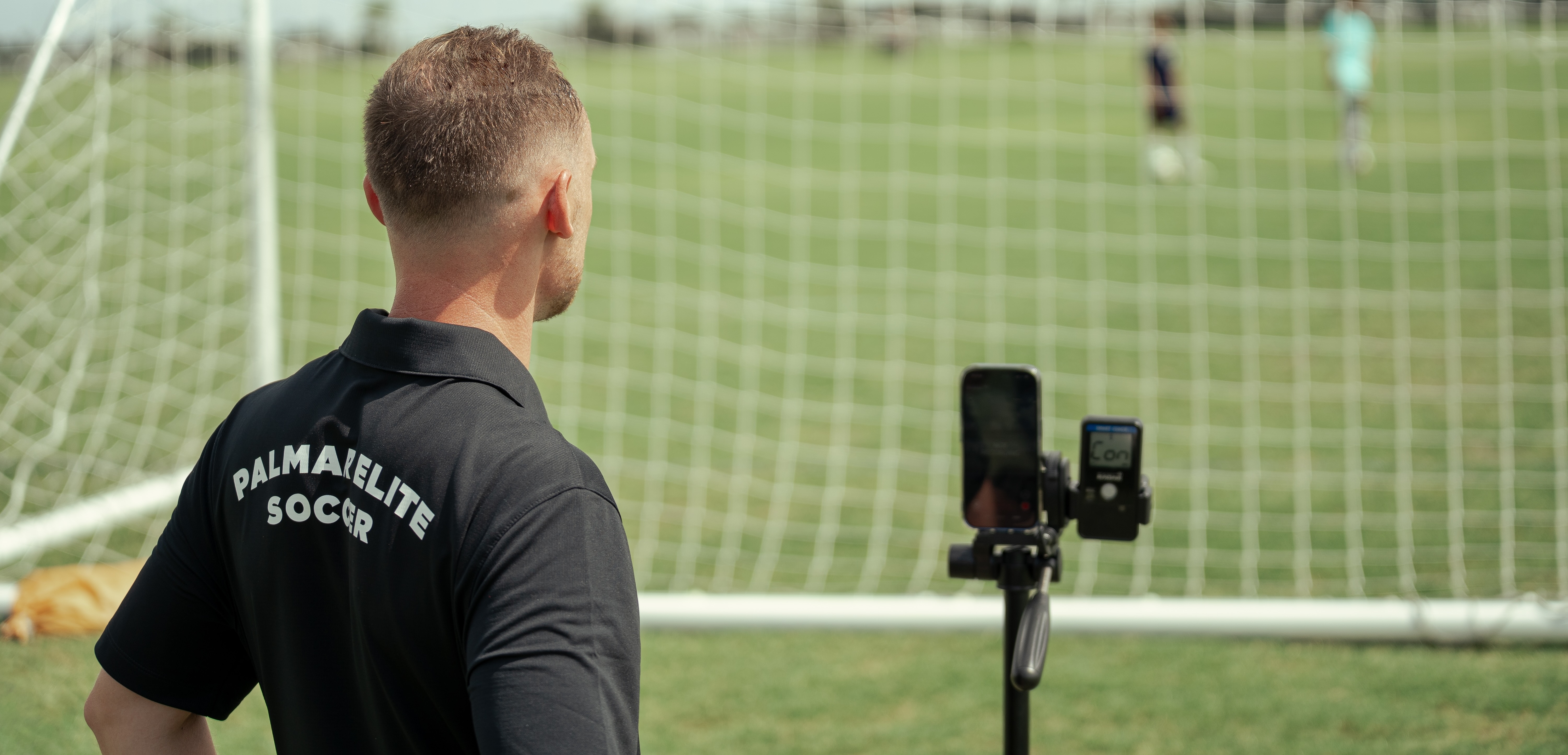 Federico next to a Pocket Radar and a smartphone on a tripod behind the goal
