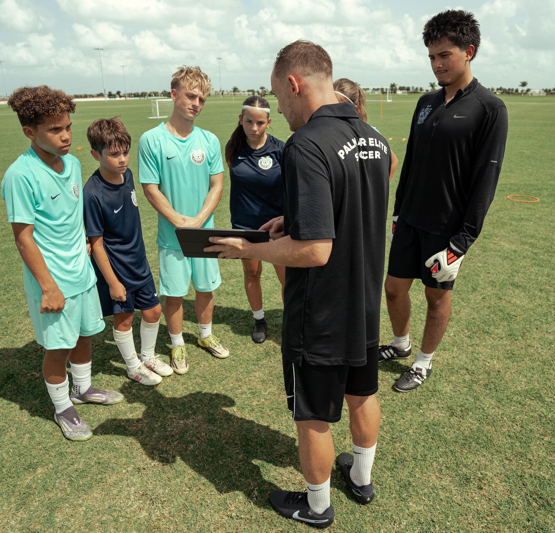 Federico shows a group of young players something on a tablet