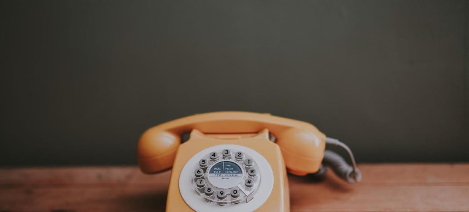 Vintage rotary telephone on a wooden desk