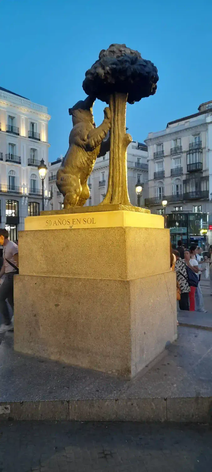Oso del Madroño en la puerta del sol con fondo de apartamentos turísticos de alquiler en Madrid centro