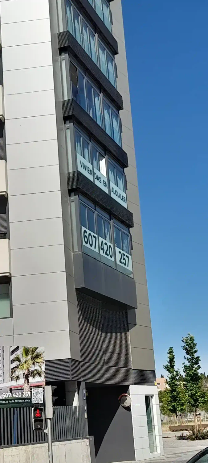 Se muestra un edificio en Madrid con cartel de se alquila piso y numero de telefono