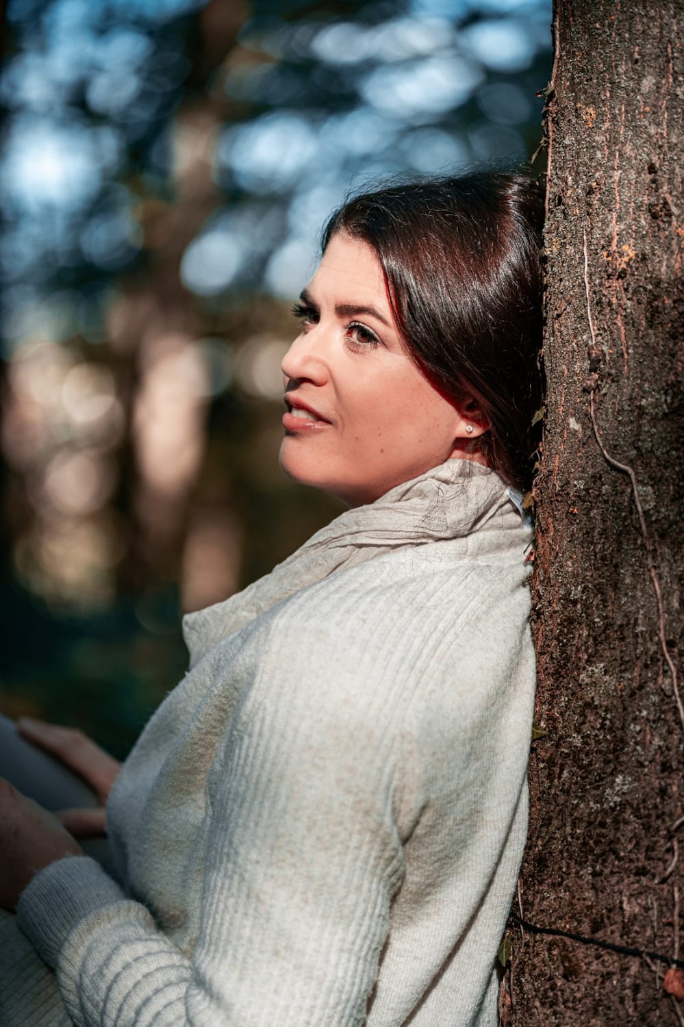 Manuela Pulkert, naturverbunden an einem Baum im Wald
