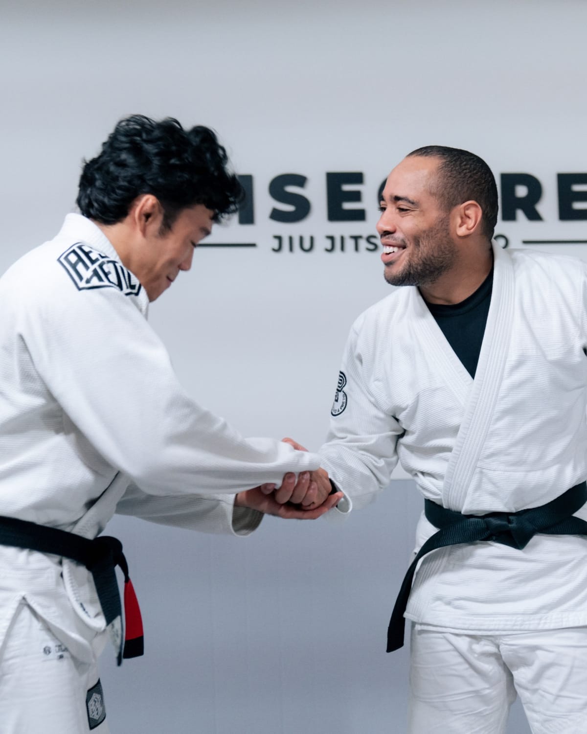 Johnatha smiling and shaking hands with a student in front of the RiseCore sign