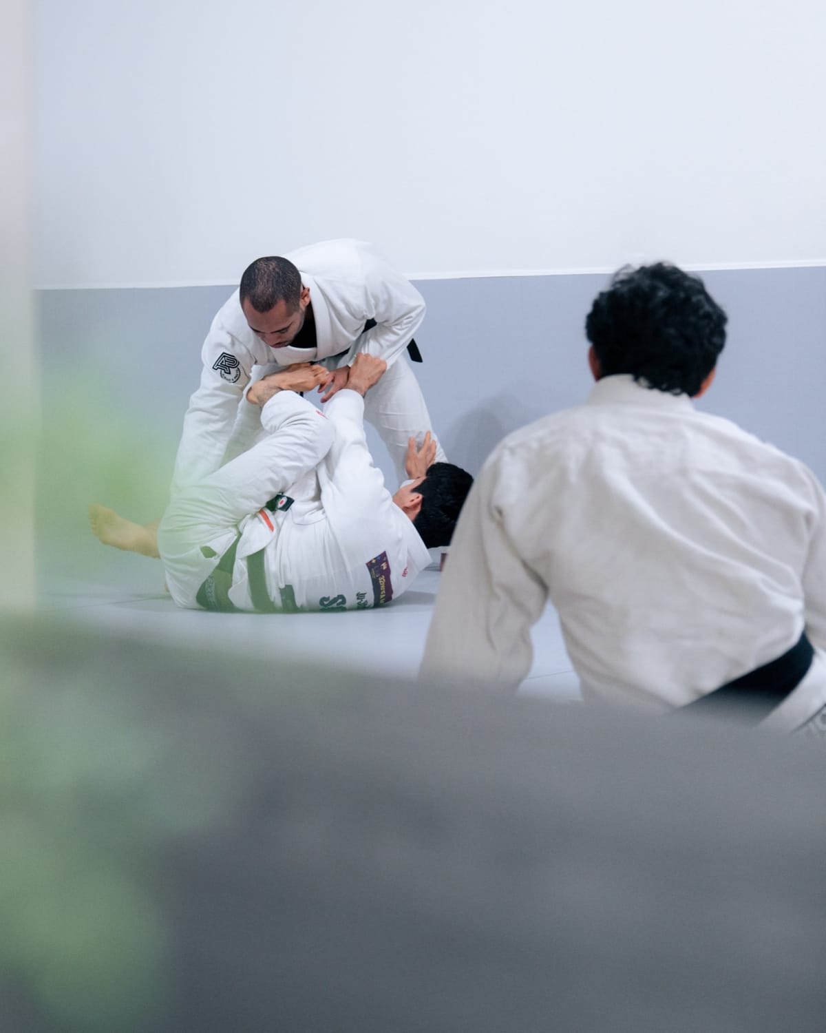 Johnatha guiding a student through a technique on the mat