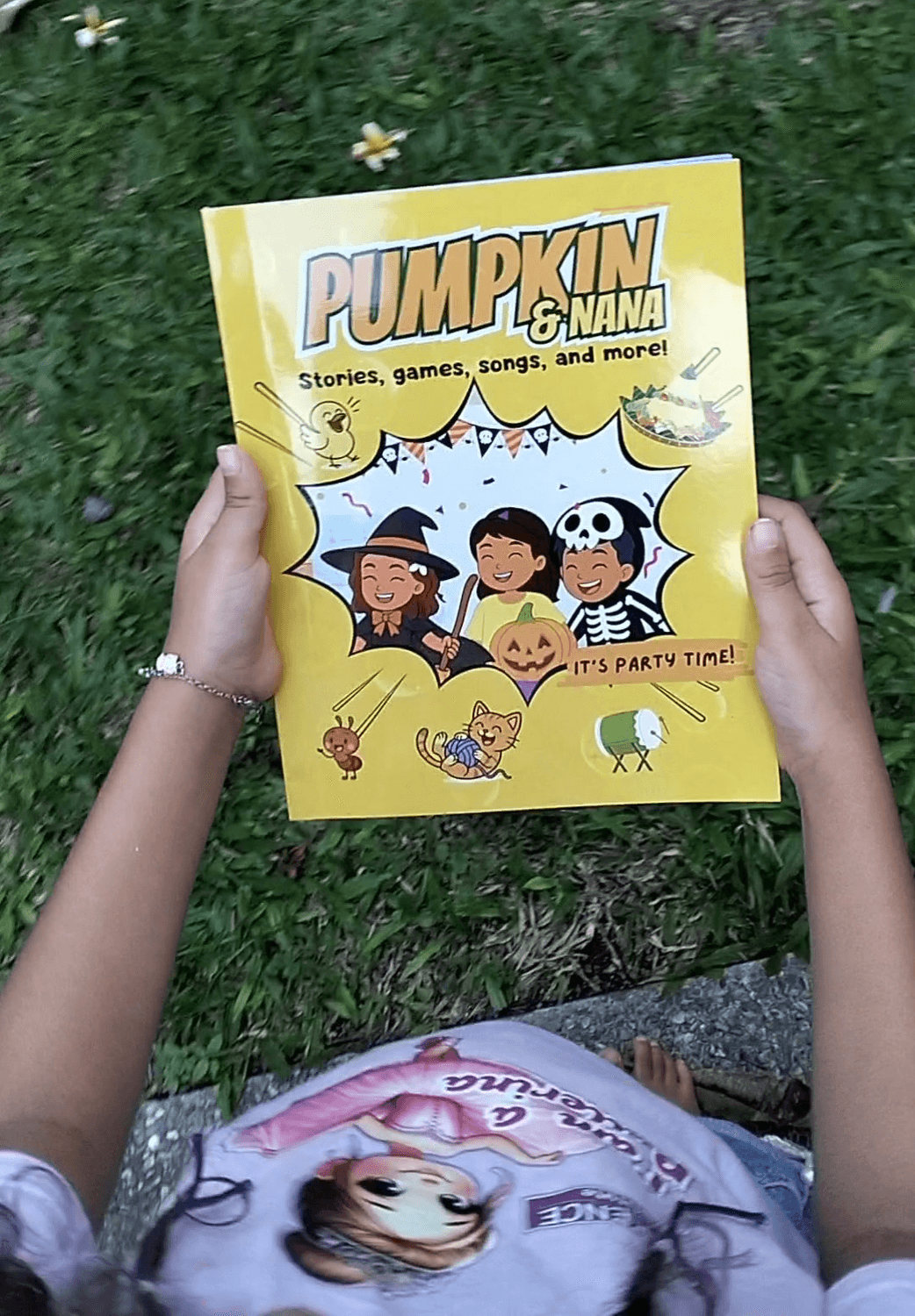 Child holding the Pumpkin & Nana activity book #2 It's party time