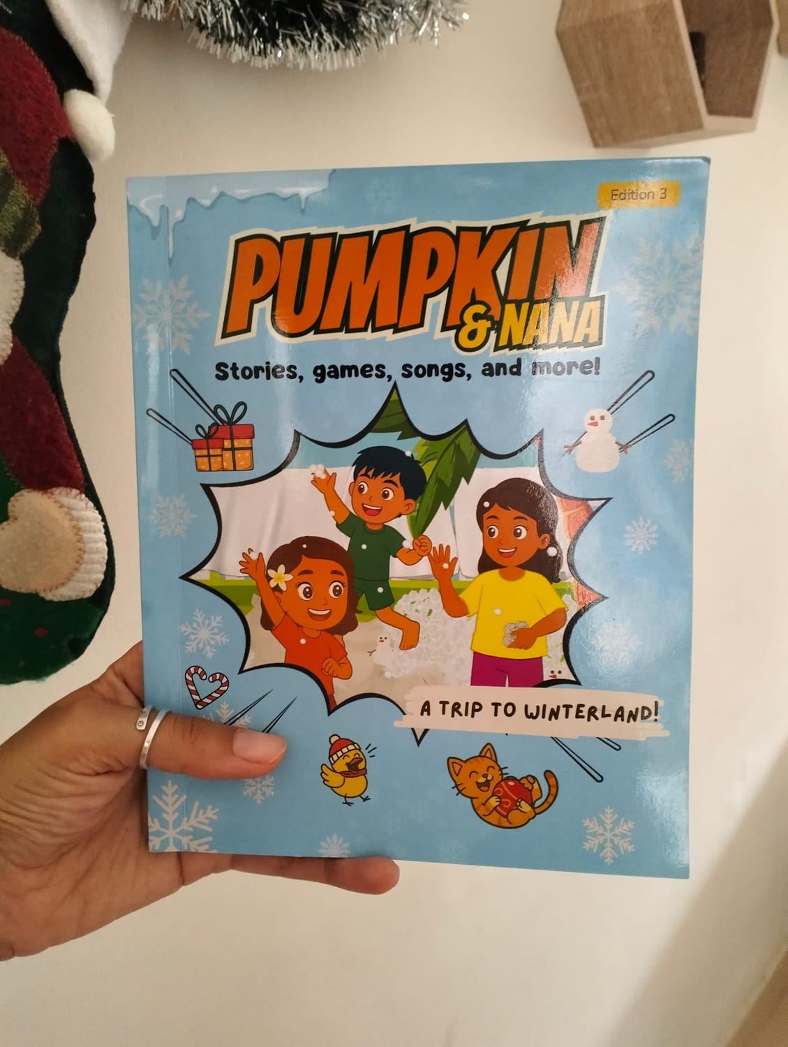 Person holding the Pumpkin & Nana Winter and Christmas activity book – A Trip to Winterland