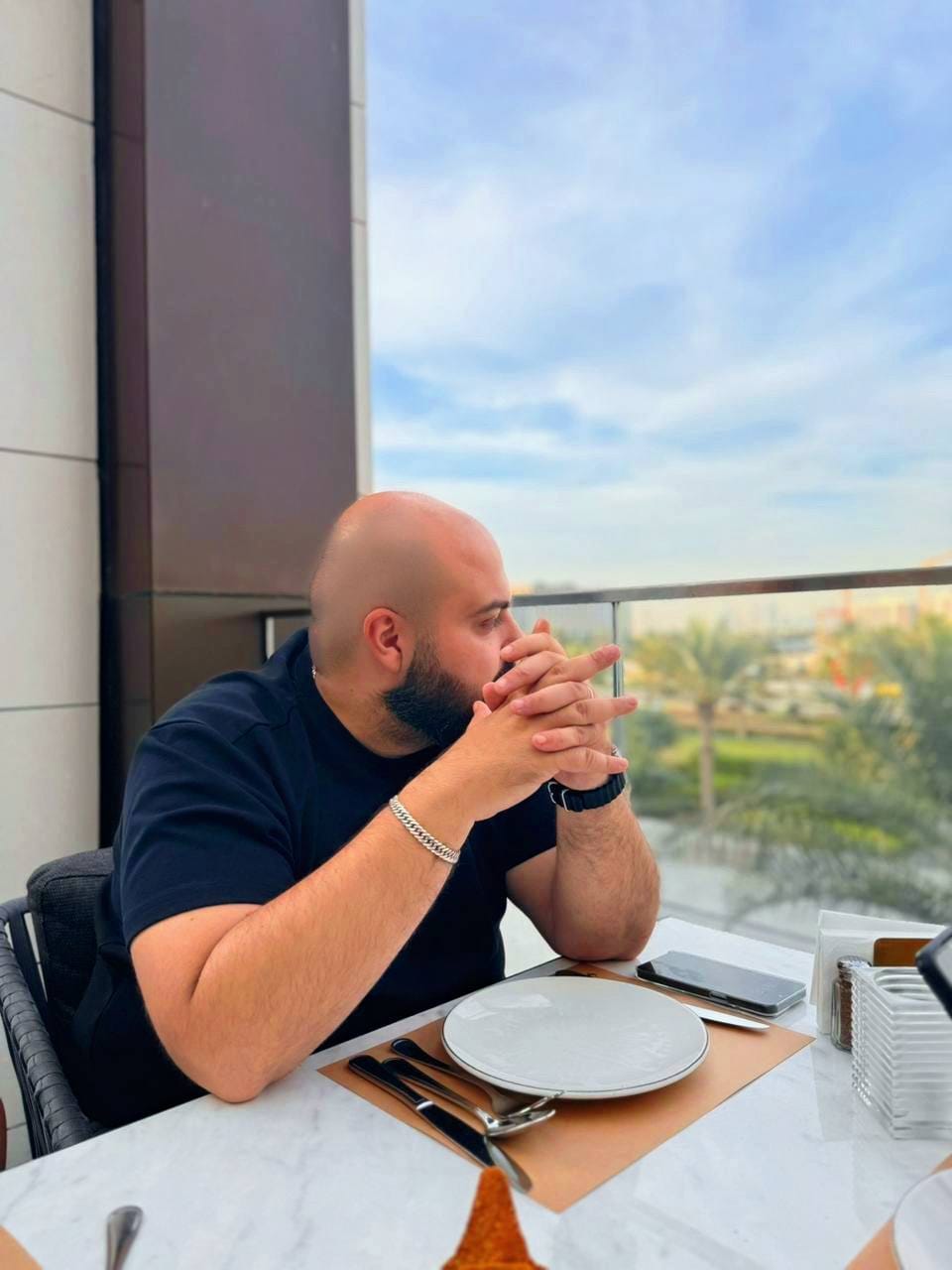خالد سعد جالساً على شرفة مطلة على المدينة.