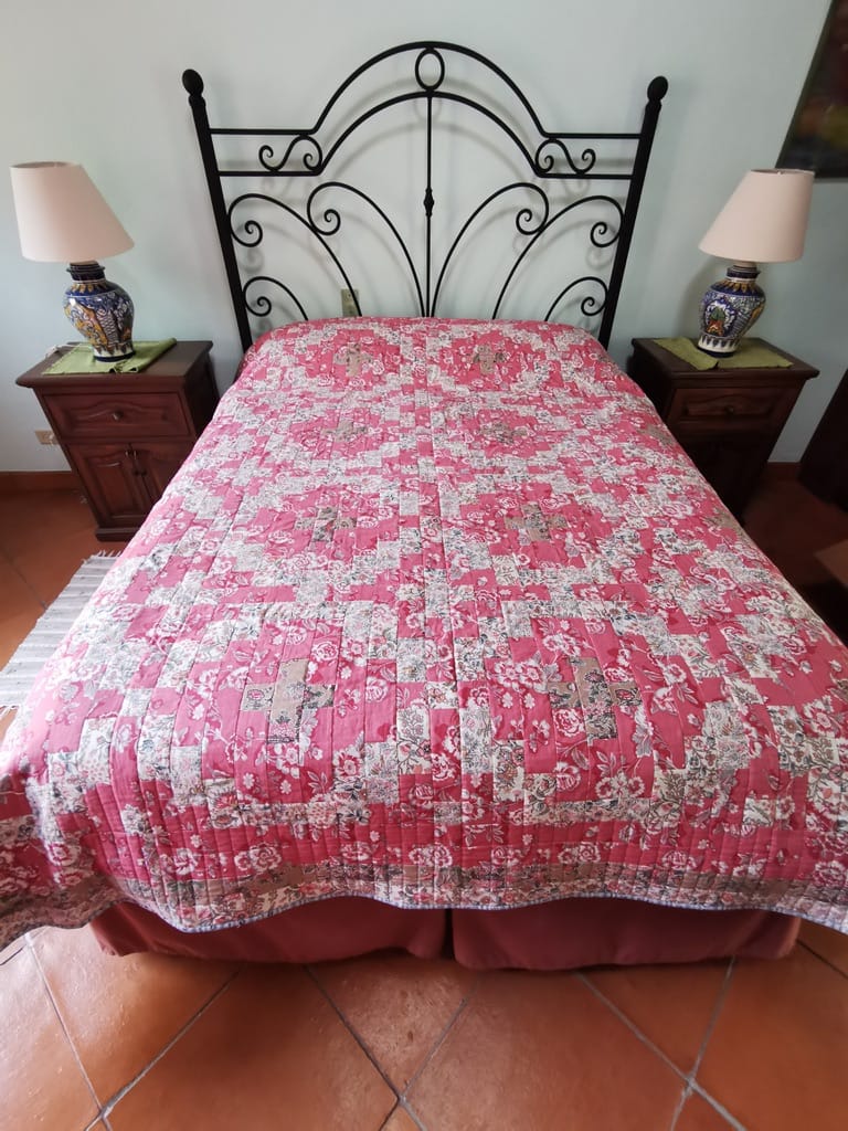 Pink floral quilt on a country cottage bed