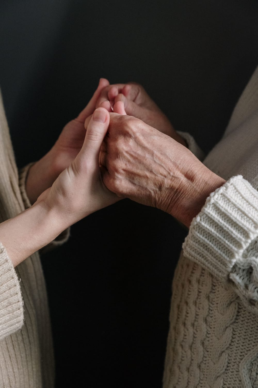Une main jeune tenant tendrement la main d'une personne âgée