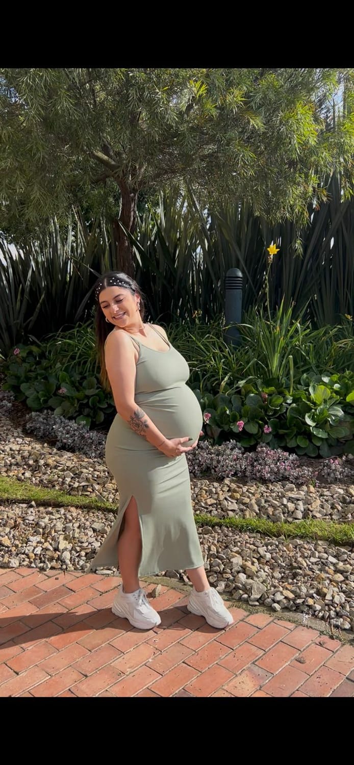 Gabriela durante su embarazo, sonriendo en un jardín