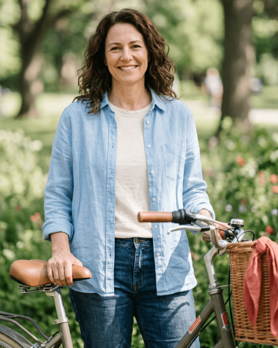 Mujer sonriendo junto a su bicicleta en un parque