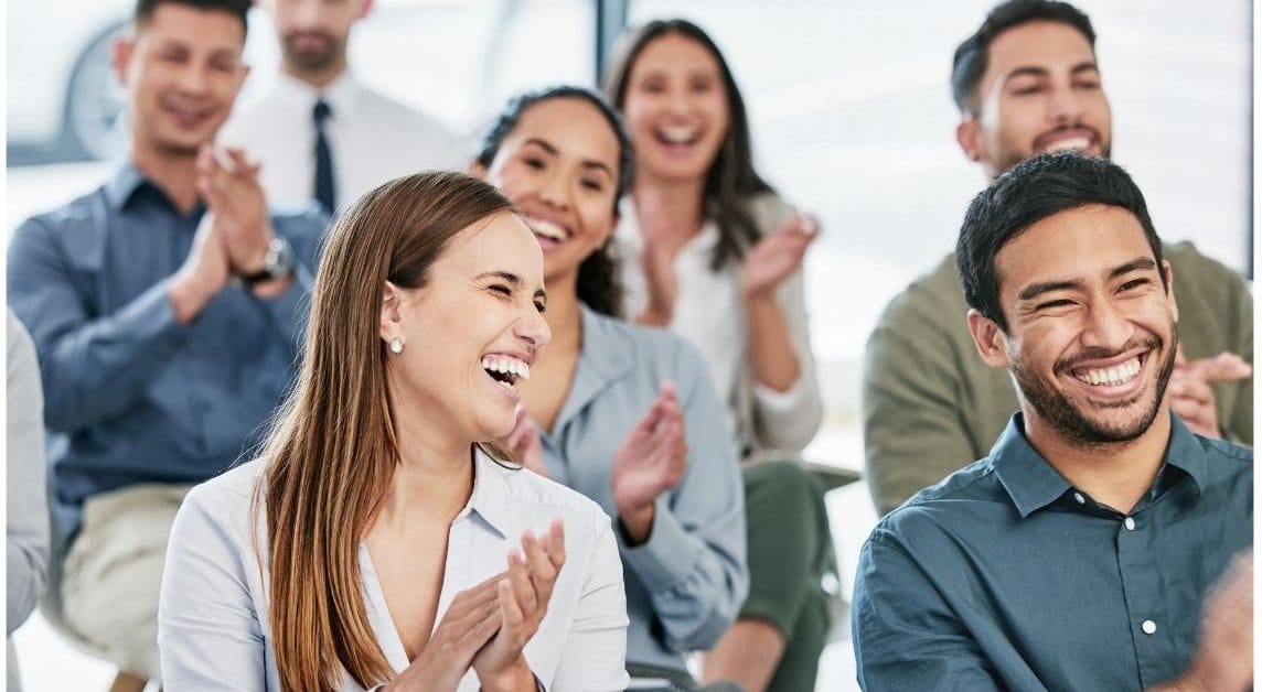 Smiling workshop participants applauding together