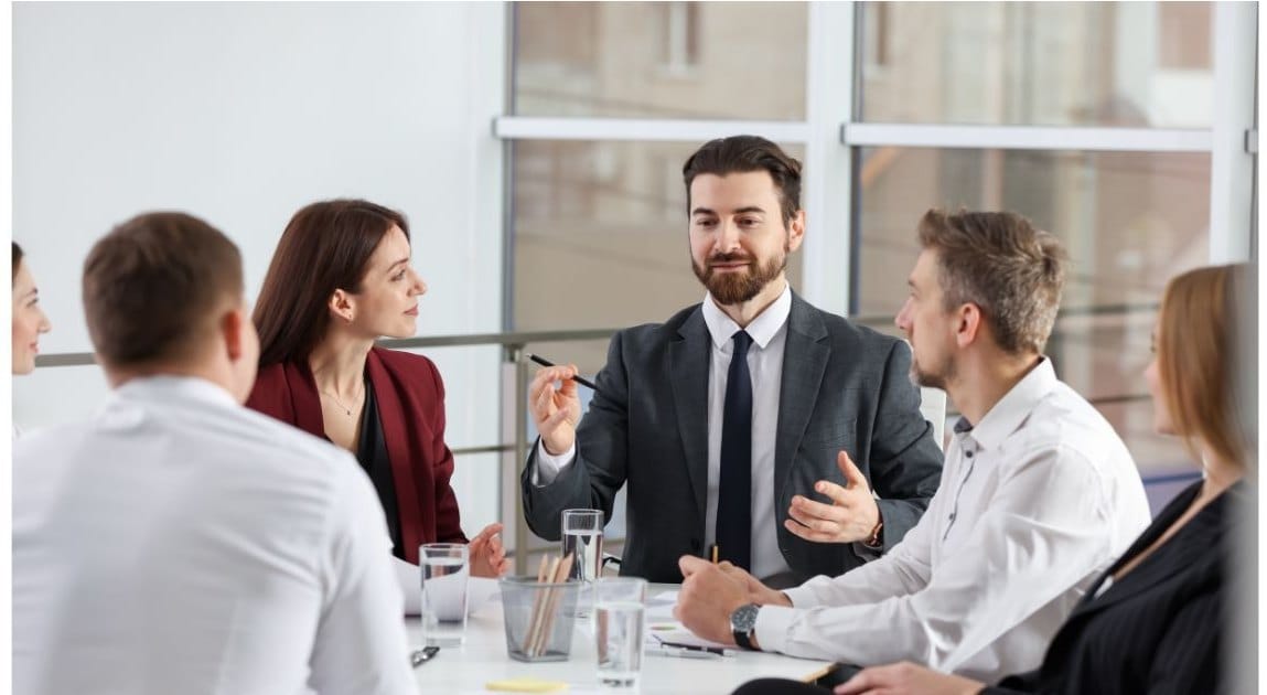 Professionals in a meeting around a table in a bright office