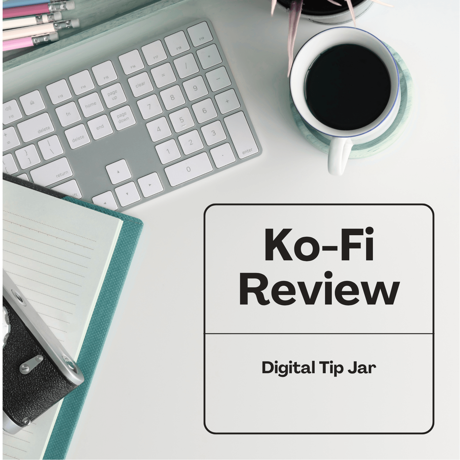Keyboard, coffee and a blue notebook on a desk with the title Ko-fi Review.
